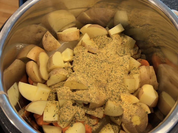 Adding the Base Ingredients: Place the Mad Dash Fixes Cheesy Chicken Enchilada Soup Mix, turkey broth, potatoes, and carrots into your Instant Pot. These core ingredients will form the base of your soup.
