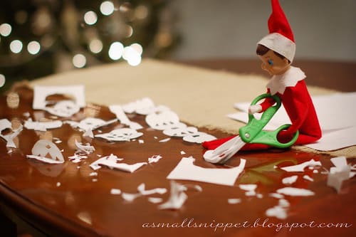 Elf on the Shelf Cutting Paper Snowflakes