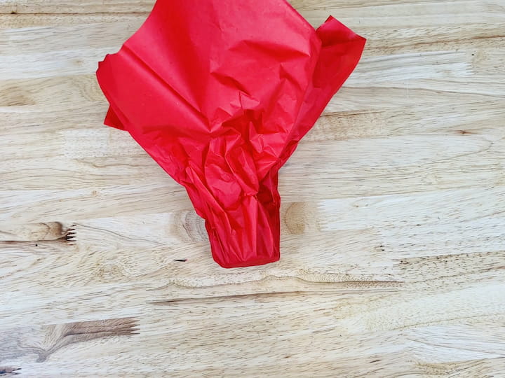 Gather the tissue paper around the gift and optionally tie them off with ribbon.