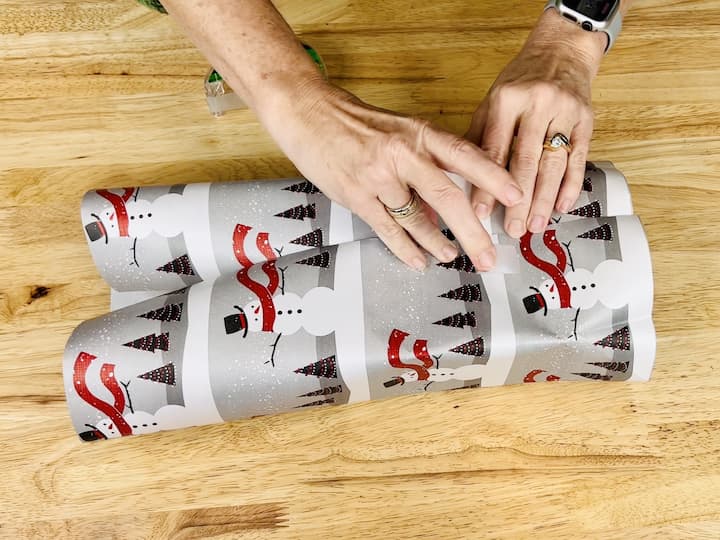 Place your box on the wrapping paper and fold the paper over the gift.