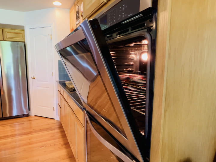 Leave the oven door open after cooking to heat your home while it blows out the oven to cool it down.  Additionally, running the self-cleaning cycle can generate additional heat.