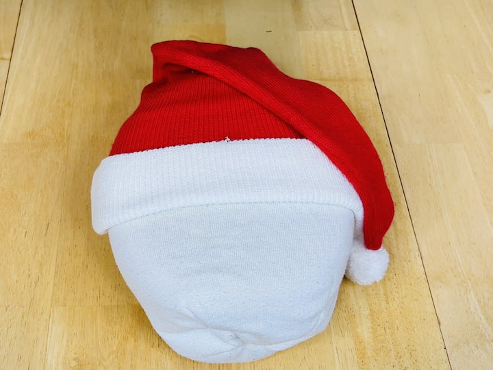 Place the Santa hat over the container, covering the white hat.