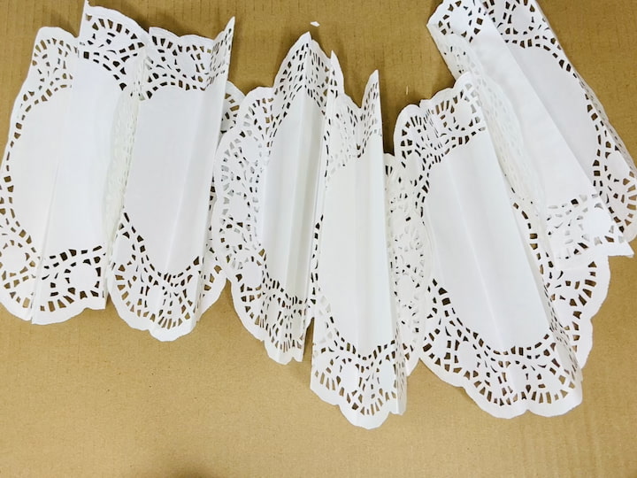Repeat for All Six: Repeat the accordion folding process for the remaining five doilies.