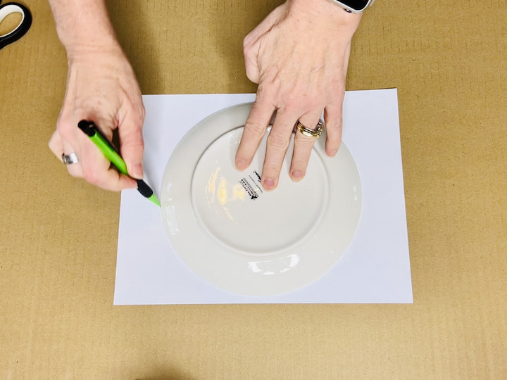 Trace a circle on a piece of paper using a plate.
