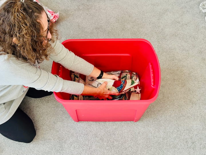 Chas wrapping fragil holiday decor with placemat and soft items already packing