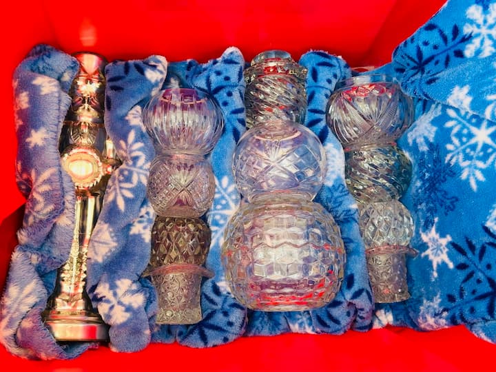 Holiday blanket being used to pack fragile items in a storage container