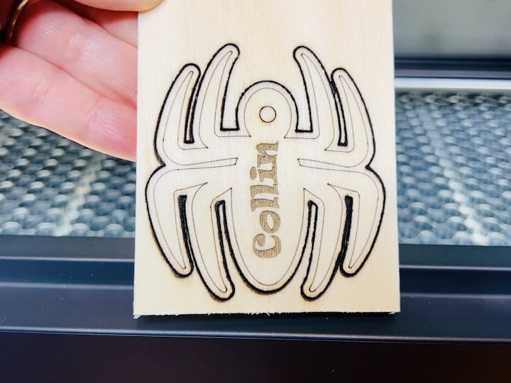 Step 4: Complete the Spider Ornament Once the machine finishes its work, carefully remove the spider ornament from the laser cutter. As with the dolphin, this one should pop out easily. Use a small tool to clean up any remaining pieces between the legs, and your spider ornament is complete!