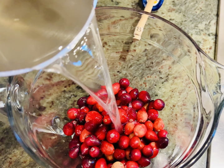 Once the sugar is fully dissolved, turn off the heat and pour the simple syrup over the cranberries. 