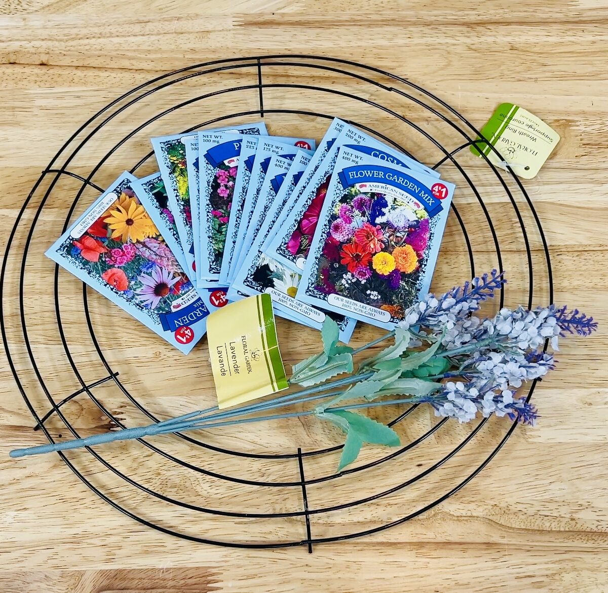 overhead shot of materials needed for seed packet wreath: seed packets, wire wreath form, faux flowers