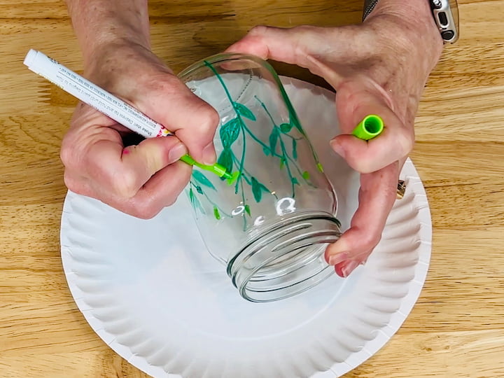 overhead shot of finished stems and leaves application of paint pen on mason jar