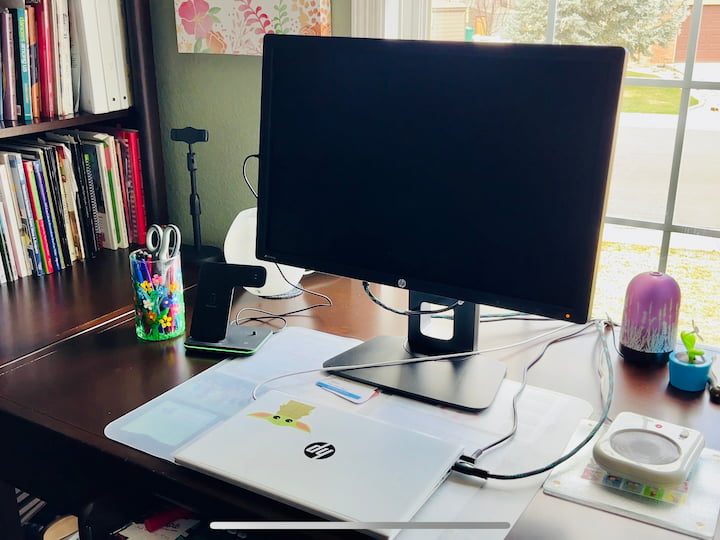 flower craft vase holding office supplies on a computer desk in office