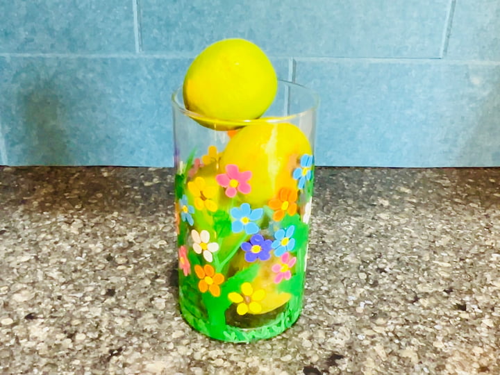 flower craft vase on the kitchen counter holding limes and lemons