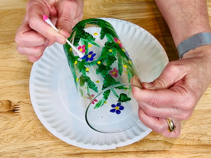 Overhead shot of flipped qtip painting blue flower petals on flower craft vase