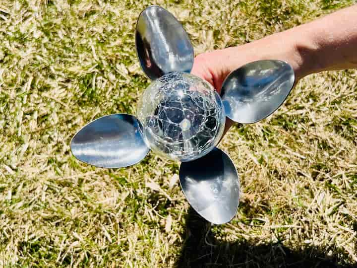 I continued to put all of the other spoons onto the solar light. Then I wrapped the whole thing one more time with the gaffer's tape. This solar light flower is complete. 