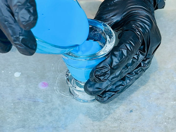 showing how to tip the candle holder upside down and pour the glue inside the candle holder.