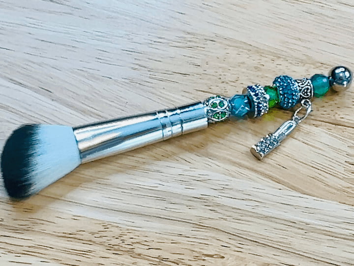 This is the makeup brush. I started adding the beads to the handle. There are lovely beads to choose from—lampwork beads, crystal, acrylic, metal, rubber, and natural stone.