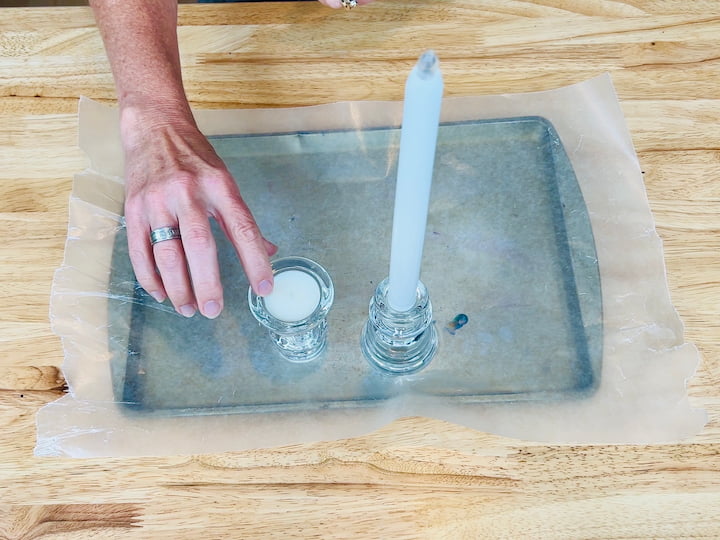 candle holders on top of metal tray and wax paper to protect counter surface for DIY