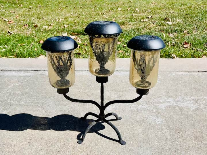 I used larger solar lights for this one. I pulled the base off. Then I placed all the solar lights into the top openings of the candle holder. 