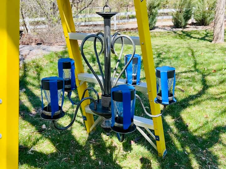 painters tape holding solar lights for silicone to dry