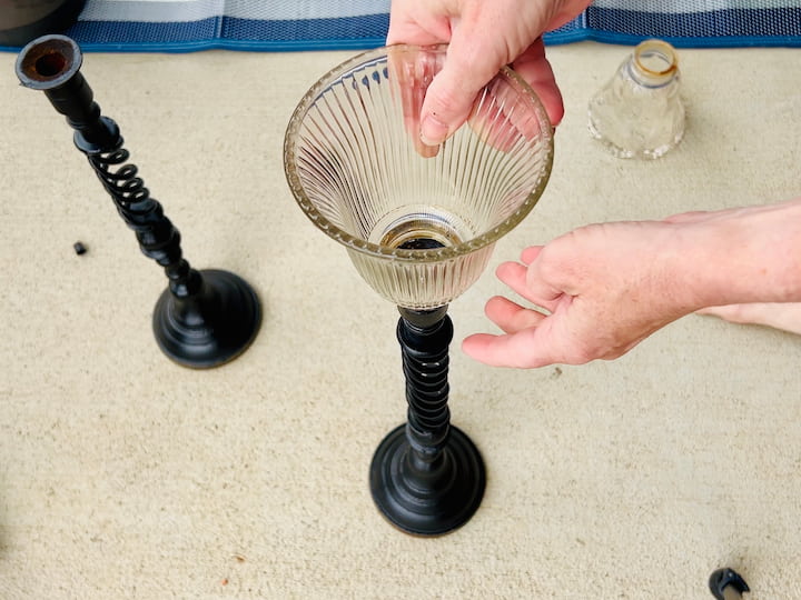 I'm going to repeat this process with the other two candle holders, adding some of the Fix All adhesive to some more light fixtures that I found and placing them on top of the candle holders. 