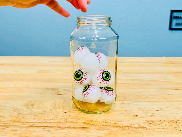 For this jar, I found a package of 12 eyeballs at the Dollar Store, and I'm just adding all of these inside the jar.