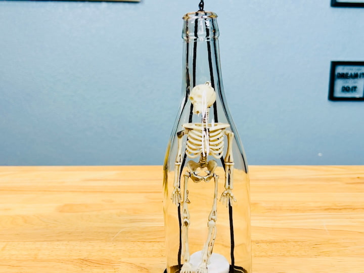 I placed a skeleton inside this bottle candle holder