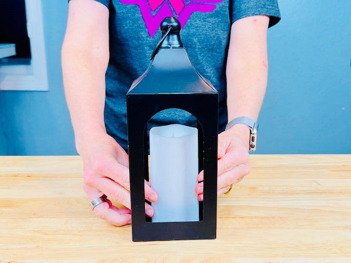 Placing a battery operated candle in a lantern