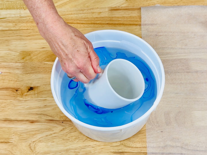dipping mug into mixture