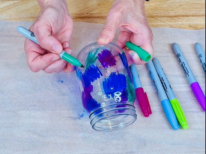coloring the glass jar with sharpies