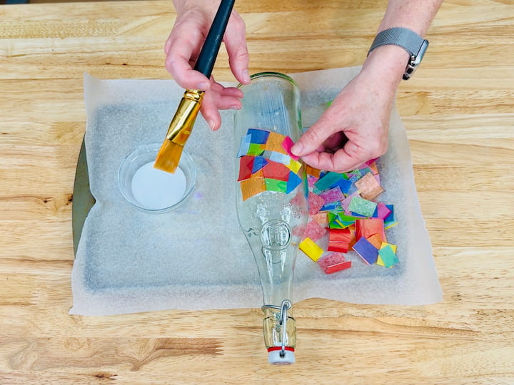 adding mod podge and tissue paper to the bottle