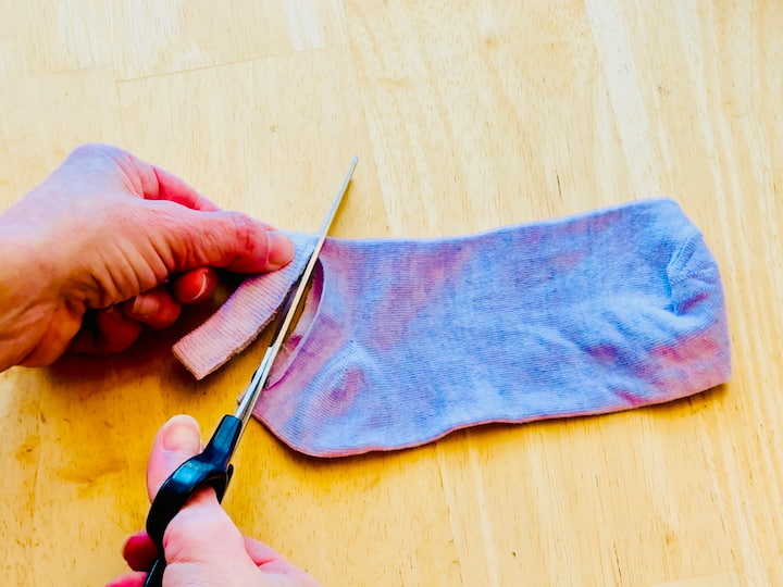 Chas cutting the top band off of a sock