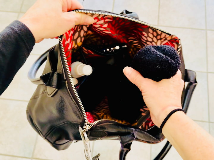 Chas placing glasses in a sock in a purse