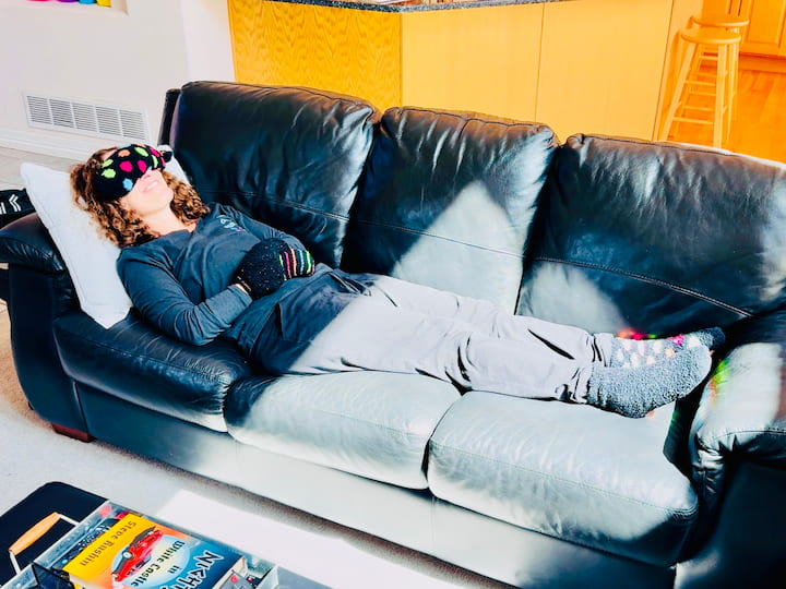 Chas laying on couch with socks on hands and feet