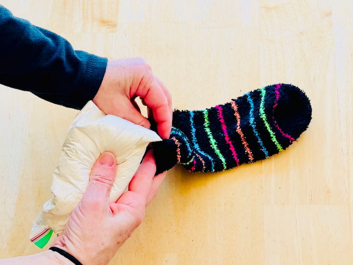 Placing a bag of flour into an old sock
