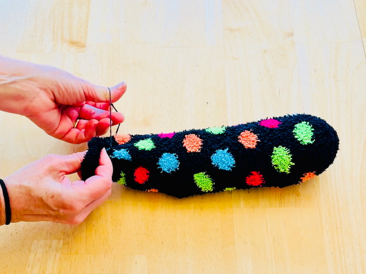 Place a rubber band over the end of the sock