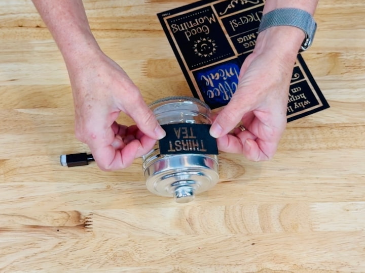 Applying stencil to glass jar for engraving