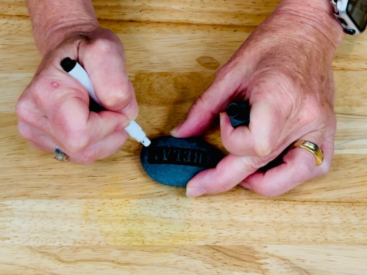 using a dry erase marker over a stencil onto the rock