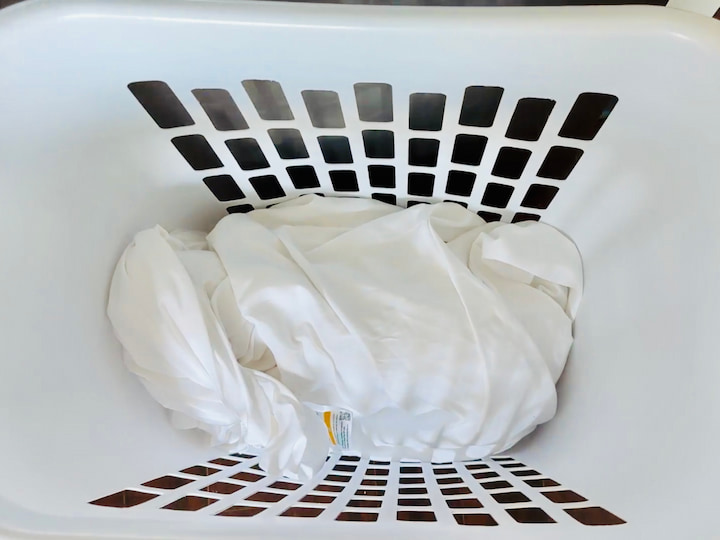 pots and pans wrapped in sheet in the bottom of a laundry basket