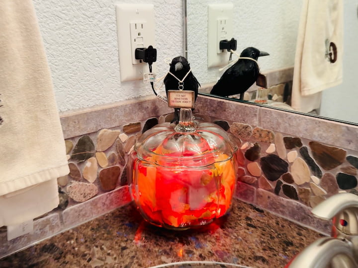 pumpkin jar with leaves and lights on display
