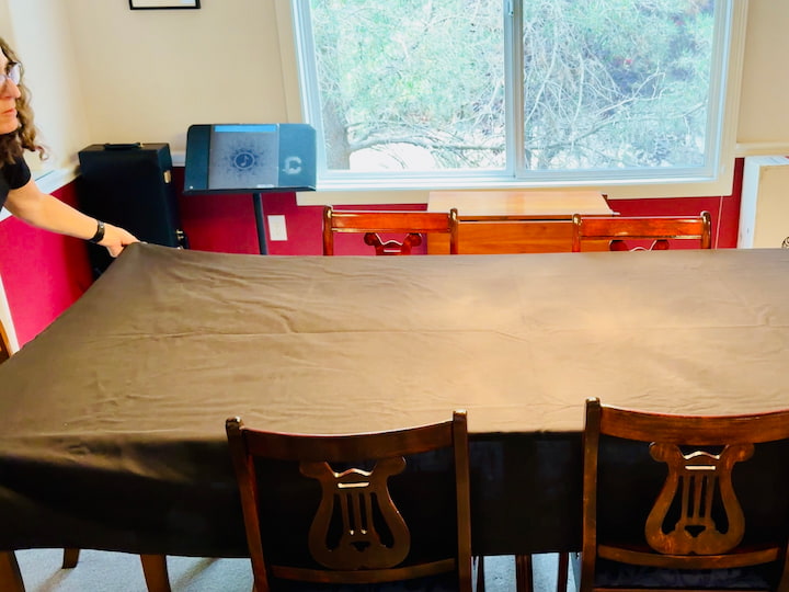 Chas placing black table cloth onto dining table