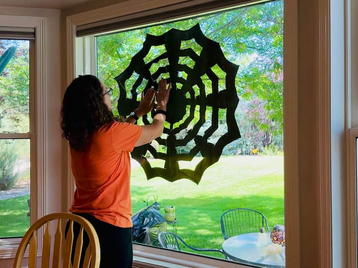Chas using static to hang the spider web onto the windwo