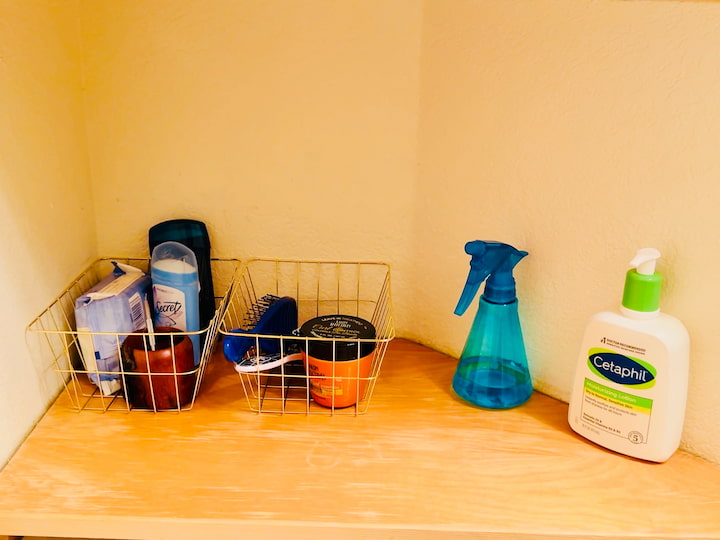 basket with hair supplies, basket with deodorant, spray bottle, and lotion