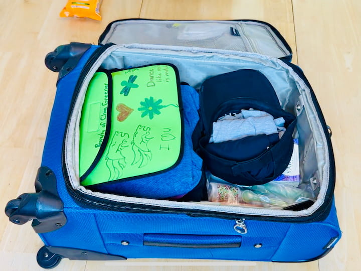 Garbage bag tucked in for dirty laundry or wet clothes.