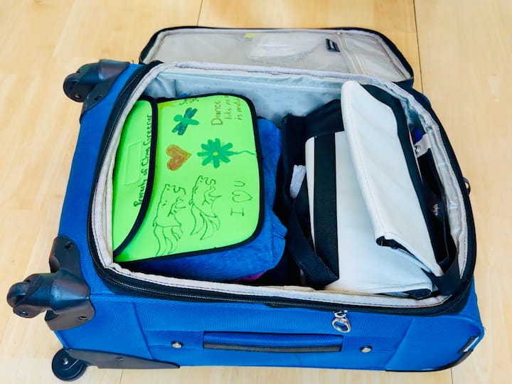 Toiletry bag and hat (stuffed with pajamas) placed on top.