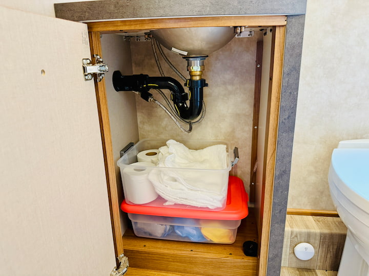 Layering Containers: I used Dollar Tree containers to organize items. Less-used items go in a container on the bottom.
Top Container: I placed a second container on top to hold essentials like toilet paper and washcloths.