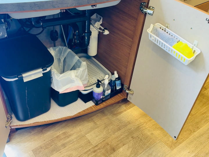 Vertical Door Storage: Add Command Hooks to the back of the cabinet door and hang a Dollar Tree container for dish cleaning supplies. Use the existing door handles, or an over-the-cabinet towel rack for hand towels.