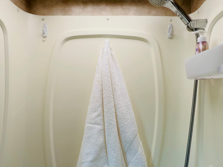 Towel Rack Hack: Place Command Hooks inside the shower space. You can clip needed items onto them,