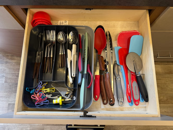 Utensil Holder: I use an adjustable utensil holder with rubber stops to keep it from sliding around.

Be Realistic: We only have two people, so we only store four spoons, knives, and forks. No need to keep a set of 12! Edit down your duplicates to free up space.

Adjustable Measuring Tools: I love items that save space, like adjustable measuring spoons and teaspoons. Keep your eye out—you sometimes find these at Dollar Tree, too!